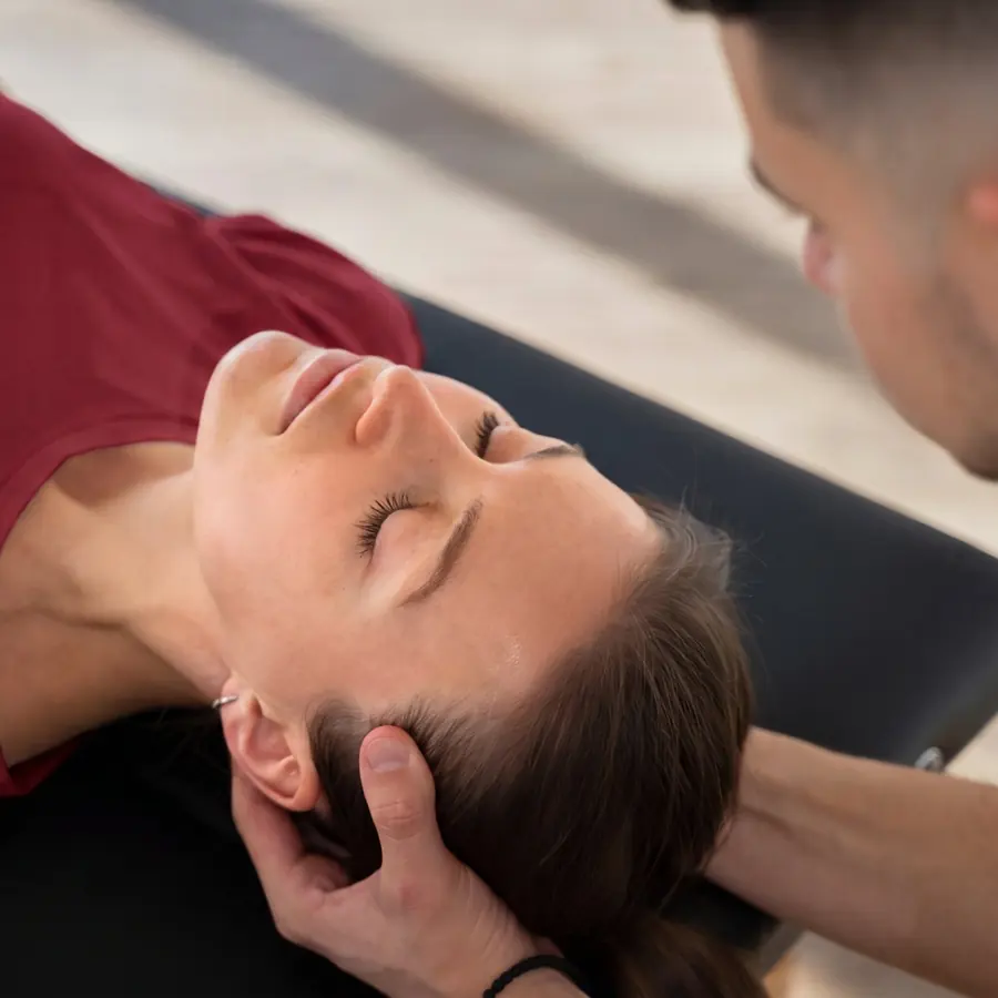 Clinician cradling a patient's head as she lies on an exam table