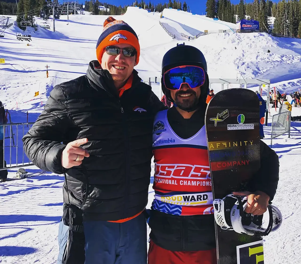 Corey Zalewski with Dr. Jeff McWhorter Corey Zalewski holding his snowboard beside Dr. Jeff McWhorter at a snowy race venue