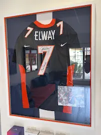 Framed signed John Elway number 7 jersey on a clinic wall