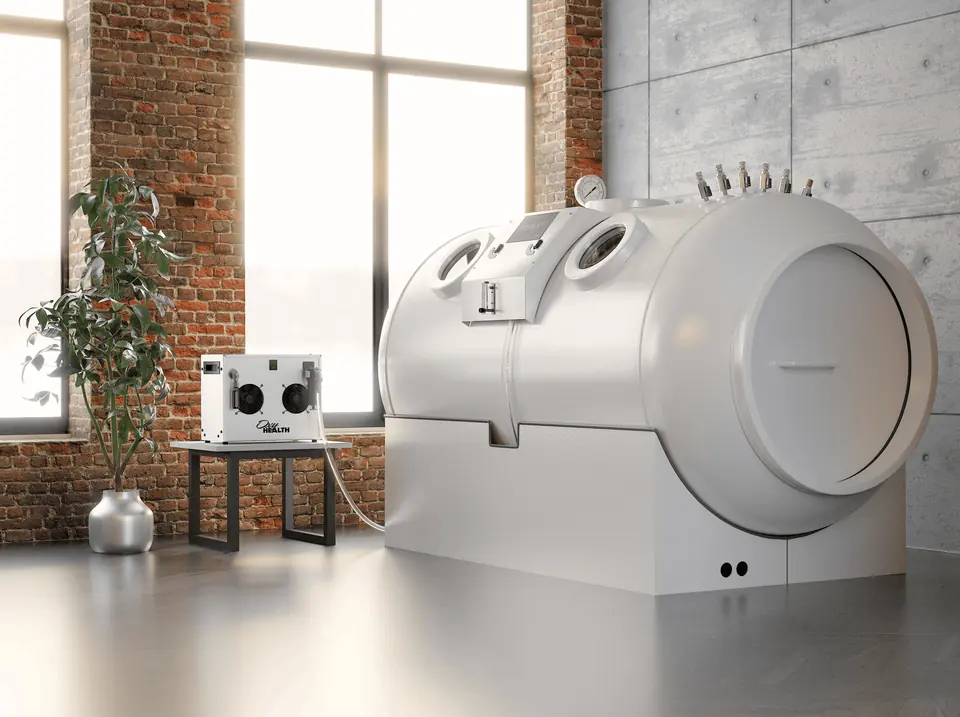 Hyperbaric chamber A white hard-shell hyperbaric chamber beside an oxygen unit in a brick-walled room